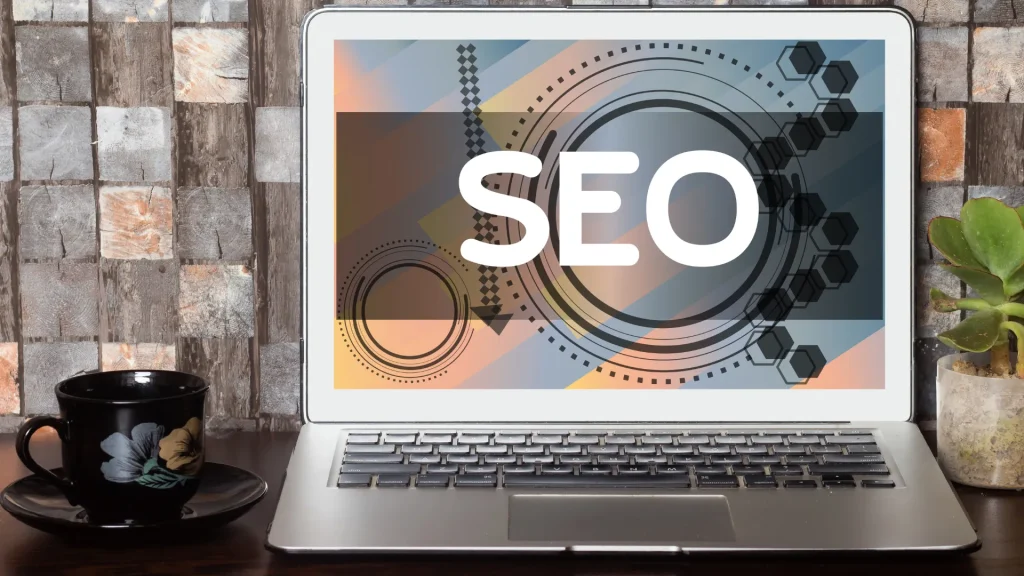 Laptop displaying SEO services for restaurant optimization with colorful patterns