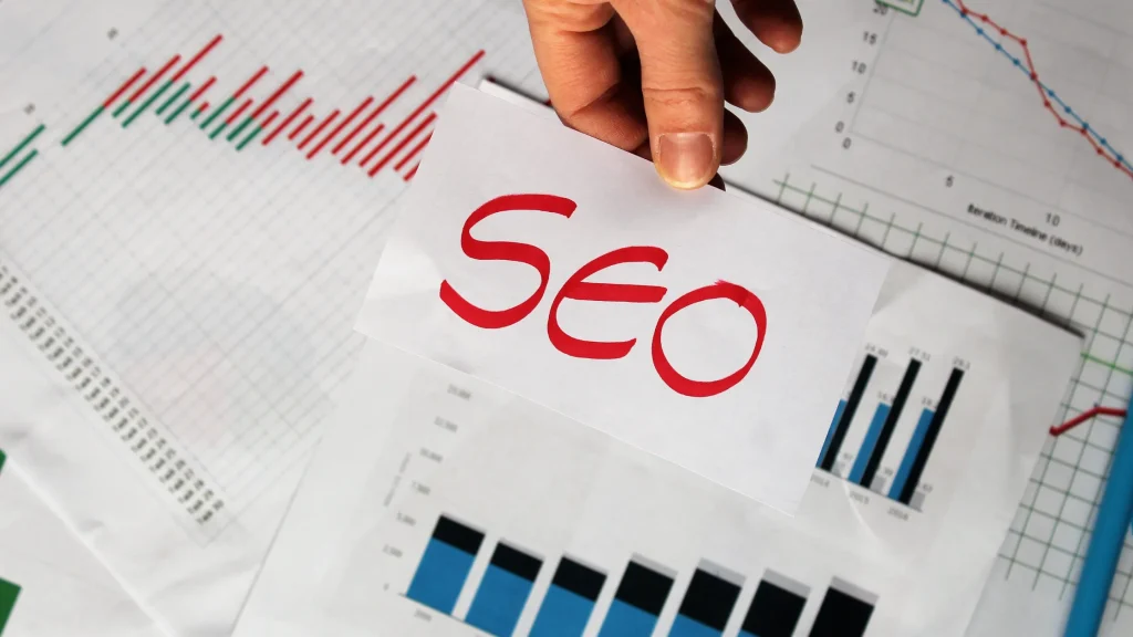 Hand holding SEO card over data charts, symbolizing the importance of an SEO Competitor Analysis Report Template for performance tracking.