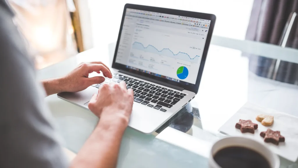 A person analyzing SEO data for coaches on a laptop, showing website traffic and performance metrics.
