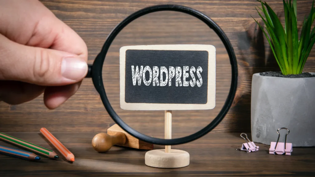 A magnifying glass focusing on a small blackboard with "WordPress" written, symbolizing agence SEO WordPress expertise