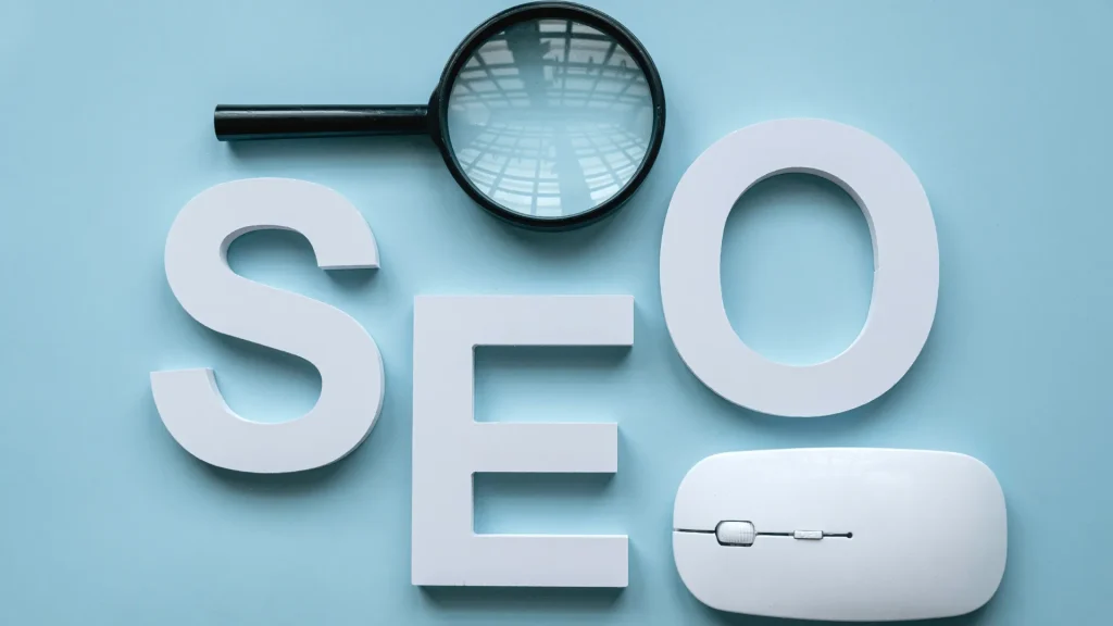 The word "SEO" in white letters on a blue background with a magnifying glass and mouse, illustrating agence SEO WordPress optimization.